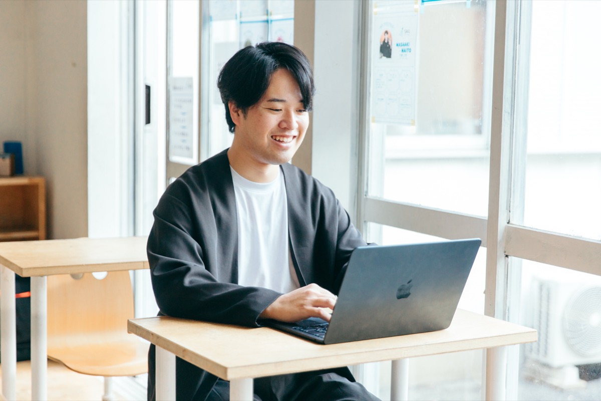 教室でノートパソコンに向かい、保護者への返信を書いている大成校の石田